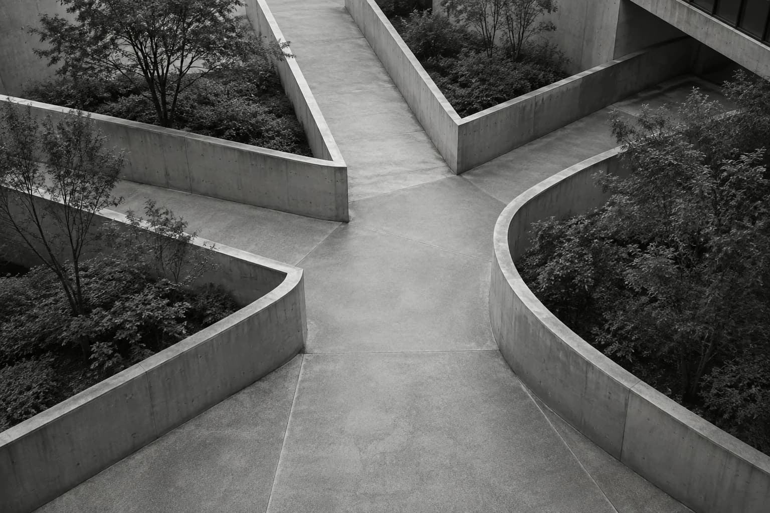 Monochrome photograph of courtyard walkways converging into one passage